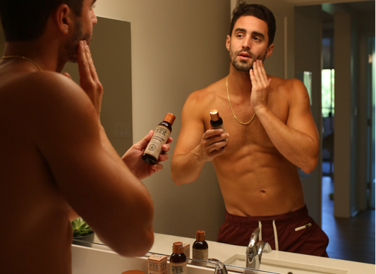 Man in Mirror Applying beard oil