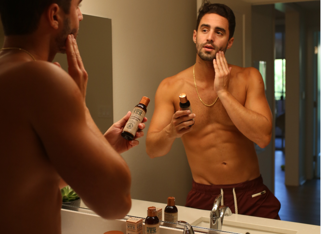 Man in Mirror Applying beard oil